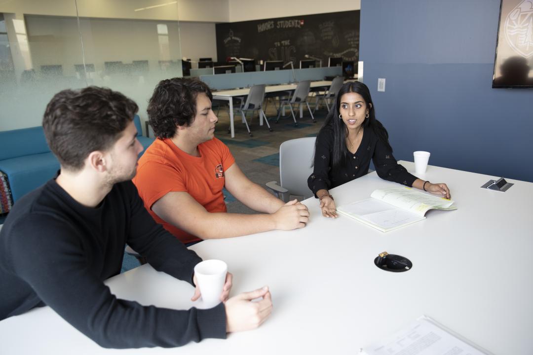 Three students sit at a table.