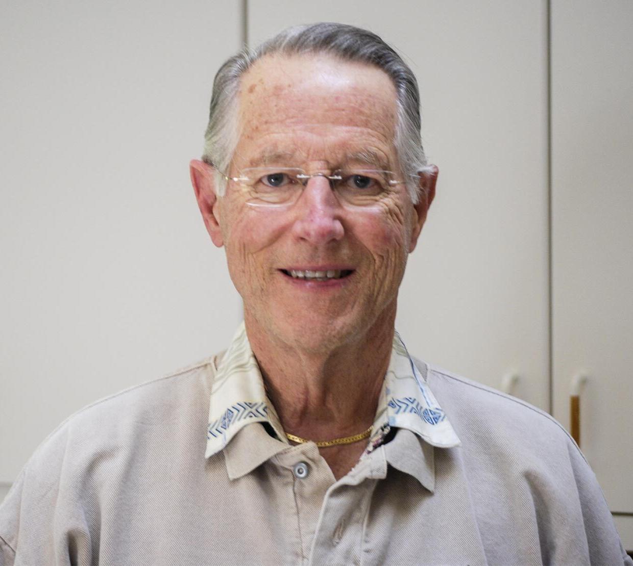 A man in grey shirt poses for photo.