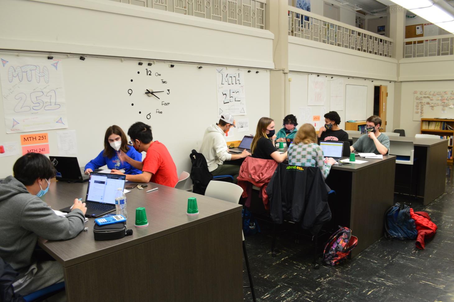 The Math Science Learning Center in Kidder Hall on the Oregon State University campus. A dozen students are sitting at desks with laptops, calculators, pencils and papers doing homework.