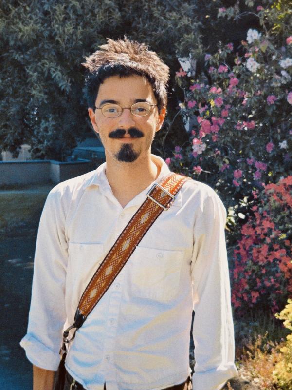 Logan Richard outside on campus with a messenger bag