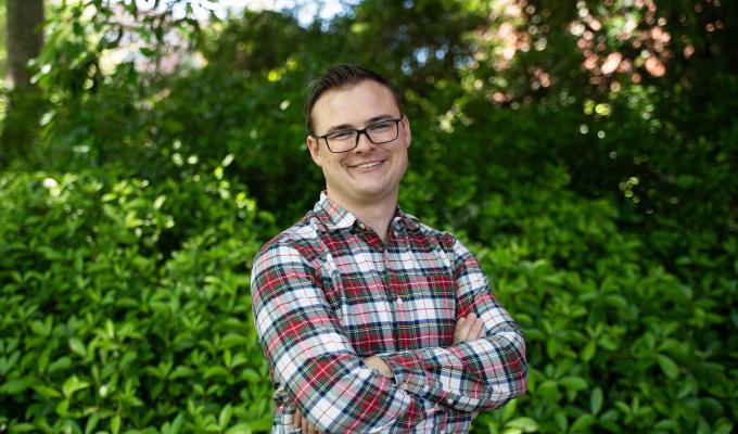 A man in a plaid shirt poses for a photo.
