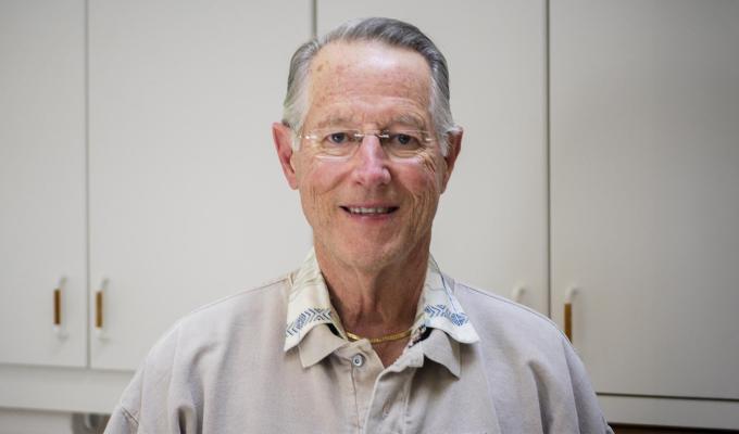 A man in grey shirt poses for photo.