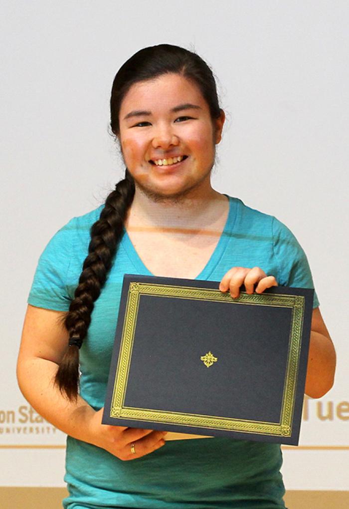 Celeste Wong holding up award on stage