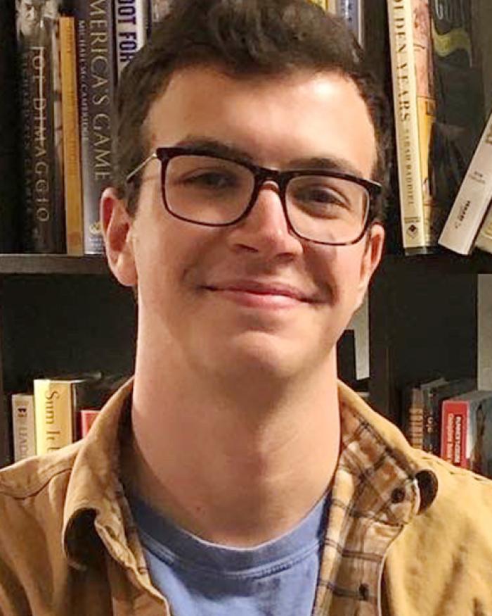 Alexander Pierson in front of bookshelf